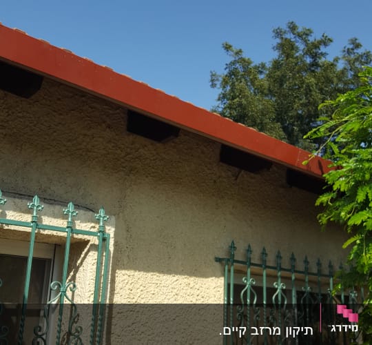 גג עם רעפים אדומים וקורות עץ מתחת